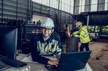 Asian project engineers who control production line facilities Use computers with AI screens,...