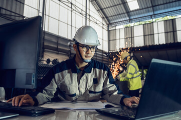 Asian project engineers who control production line facilities Use computers with AI screens,...