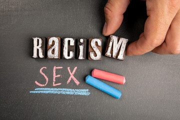 Racism and Sexism. Text and pieces of chalk on a blackboard