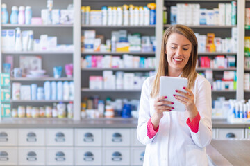 Portrait of pharmacist holding digital tablet in pharmacy. Pharmacist working with a tablet-pc in...