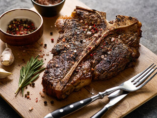 Grilled porterhouse steak on a wooden board. Close up of a succulent tender grilled t-bone steak.