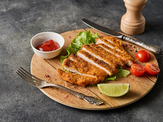 Breaded pork cutlet with cherry tomatoes, mustard and lemon.