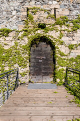 Aosta, Italy. View of an ancient wooden door of the 13th century Bramafam Castle in Via Bramafan. Vertical image. April 17, 2022.