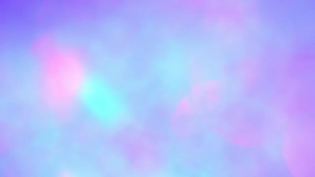 Moving bokeh background in pastel colors. The blue and pink round bokeh sparkles and shimmers. Abstract background in unicorn colors. Soft gradient transitions from blue to pink.