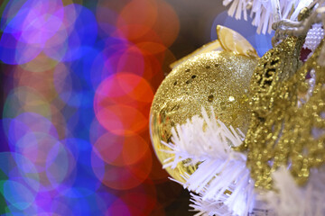 Blurred background for Christmas holidays, golden toy ball and  festive lights. New Year decorations for greeting card