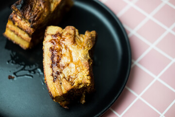 Pork belly crispy in black dish. Close up