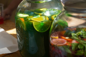 Large glass jars with soft drinks made from fresh fruits and berries.