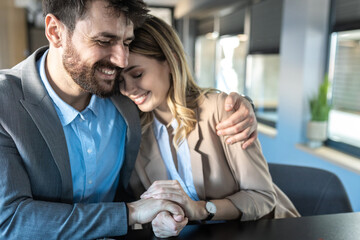 Young couple at meeting with marriage consultant in her office. They look happy and smiling, hugging