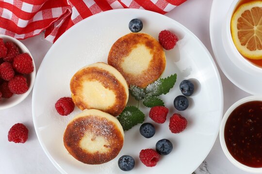 Curd Fritter With Berries In A Plate. Cottage Cheese Fritters On A White Plate.