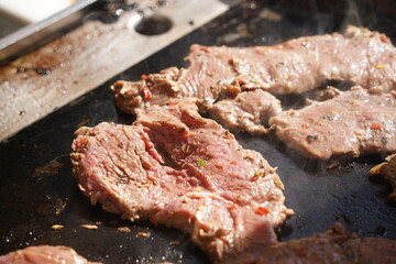 Roasting different pieces of beef for burgers and quesadillas.