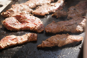Roasting different pieces of beef for burgers and quesadillas.