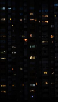 Vertical Timelapse Of Night Lights In The Building Apartments And People Moving In Them