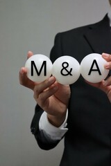 M＆Aと書かれたボールを持つ人物