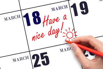 The hand writing the text Have a nice day and drawing the sun on the calendar date March 18