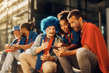 Group of sports fans watching soccer match via live stream on cell phone.