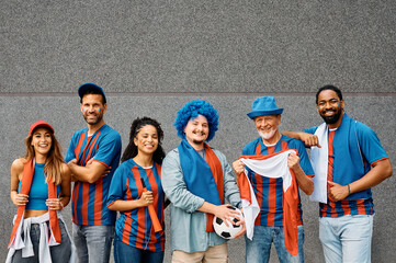 Group of happy mixed age soccer fans during world cup looking at camera.