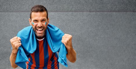 Passionate soccer fan celebrating during world cup and looking at camera. Copy space.