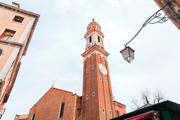 Fototapeta na wymiar Clock and bell tower of the Church of the Holy Apostles of Christ in Venice, Italy