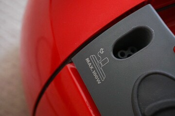 Closeup of the external output of red and black vacuum cleaner