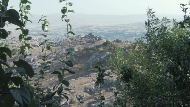 Rugged landscape wide shot through foliage Harput