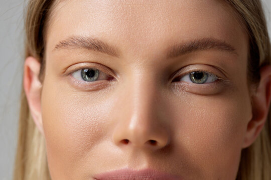 Cropped close-up image of beautiful female eyes, perfect smooth skin, natural make up.