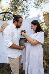 Happy young couple with their dog, expecting baby. Pregnancy concept.