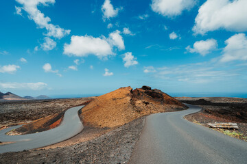 Road in volcanic arid landscape of Timanfaya National Park, Lanzarote, Canary Islands, Spain