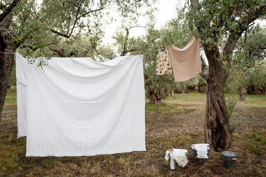 Baby clothes on clothesline drying in garden. Newborn childhood concept