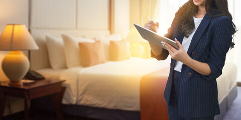 Businesswoman checking job reports with a tablet at hotel room blurred background