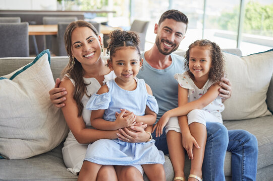 Father, mother and children smile, love and relax on the sofa together in the house living room. Portrait of happy family bonding in a lounge with happiness, care and trust in a healthy relationship