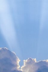Background from blue sky with sun rays across clouds