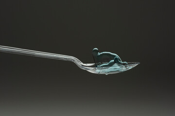 lastic spoon with water drops frozen at high speed showing surface tension and droplet splash...