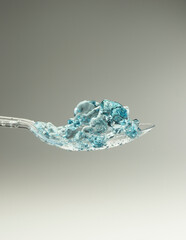 lastic spoon with water drops frozen at high speed showing surface tension and droplet splash...