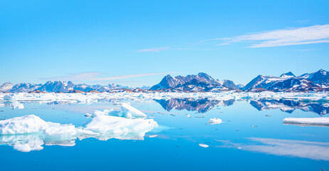 Fototapeta na wymiar Panoramic view of colorful Kulusuk village in East Greenland - Kulusuk, Greenland - Melting of a iceberg and pouring water into the sea