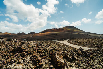 Road in volcanic arid landscape of Timanfaya National Park, Lanzarote, Canary Islands, Spain