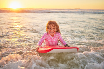 Happy, beach and girl learning to surf for sport, motivation and hawaii summer vacation. Nature, travel and smile with child surfing on board for water sports, splash and wellness ocean holiday