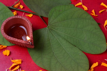 Indian Festival Dussehra, showing golden leaf and flowers with traditional diya on red background....