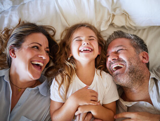 Mother, father and child happy in bed together in the morning, laughing at joke and bonding in house. Family with love in home bedroom, being funny and smile for comedy while relax with girl - obrazy, fototapety, plakaty