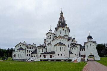 Fototapeta na wymiar White Temple of the Vladimir Skete of the Valaam Monastery. Horizontal photo of a beautiful temple against a cloudy sky