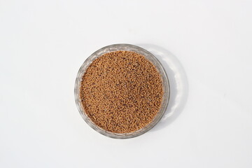 Obraz na płótnie Canvas Mustard seeds on a glass bowl, mustard seeds on white background