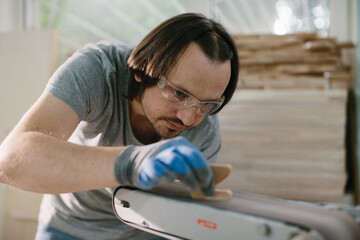 The carpenter is engaged in the manufacture of wooden toys, the grinding process.