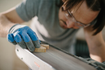 The carpenter is engaged in the manufacture of wooden toys, the grinding process.