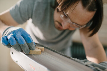 The carpenter is engaged in the manufacture of wooden toys, the grinding process.