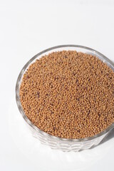 Mustard seeds on a glass bowl, mustard seeds on white background
