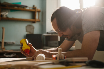 Gluing boards in a carpentry workshop. Connecting with dowels and glue. Production of children's furniture and educational games.