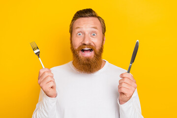 Photo portrait of nice young guy hold fork knife excited changes nutrition dressed trendy white...