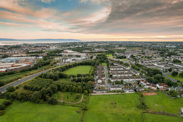 Aerial view on a city residential area with houses and park. Galway, Ireland. Blue cloudy sky. High density urban land.