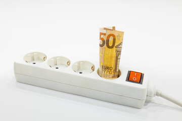 A fifty euro banknote plugged into the power strip. Expensive electricity prices concepts