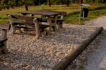 Wooden benches on the promenade in the park. massive concrete bench with a log as a support....
