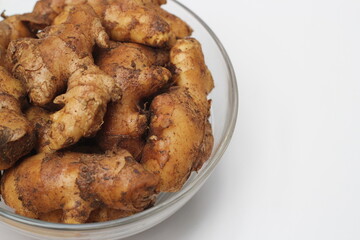 Ginger on a white background, fresh ginger on a bowl